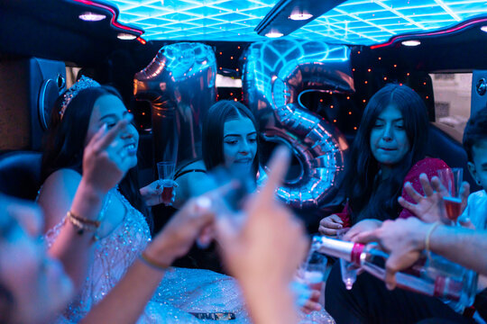 Quinceanera With Friends On Her 15th Birthday Party In A Limousine. 
