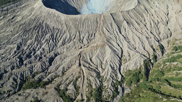 tilt cinematic view of Mount Bromo or Bromo Volcano during morining time and smokes coming from it - East Java, Indonesia