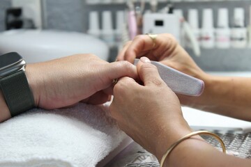 The girl does nail cleaning to the client and manicure