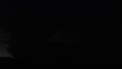 A distant cloud at night with heady lightning happening inside it
