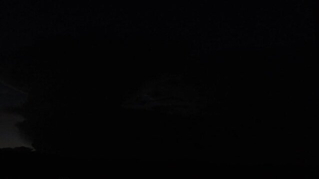 A distant cloud at night with heady lightning happening inside it