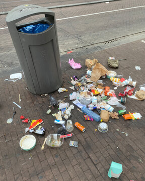 trash can with litter all around