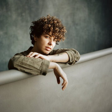 Calm curly androgynous woman looking at camera