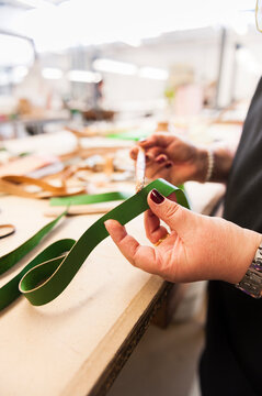 Artisan working with leather and glue brush
