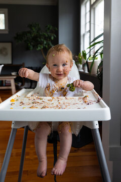Smiling baby enjoying solid food.