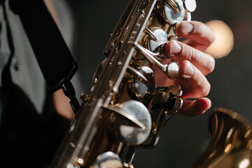 Saxophonist, jazz, blues. Close-up of saxophone and male fingers