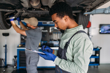 Two Mechanics Working in Garage