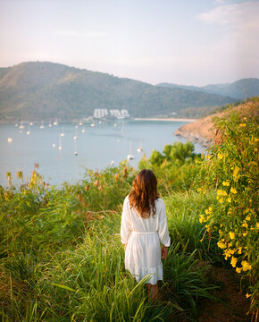 Elegant woman in white dress standing on the background of the sea