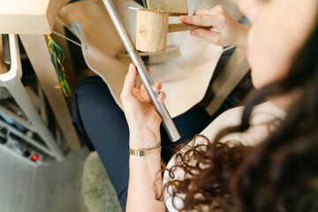 close up  of young woman working in hammering a ring to make it bigger