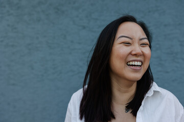 Laughing woman near blue background.