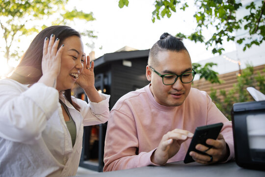 Couple at restaurant looking at digital menu on their smart phon