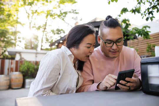 Couple at restaurant looking at digital menu on their smart phon