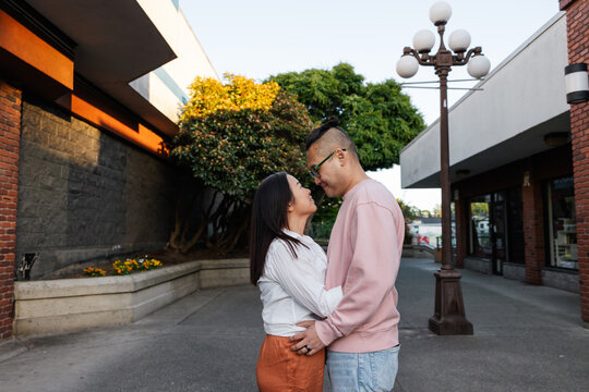 Hugging couple looking at each other outside in the city.