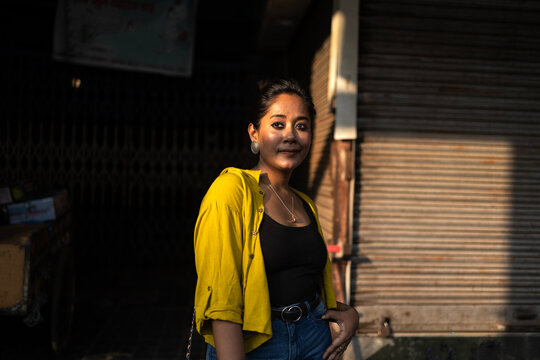 Portrait of a young lady in front of a closed shop in urban city