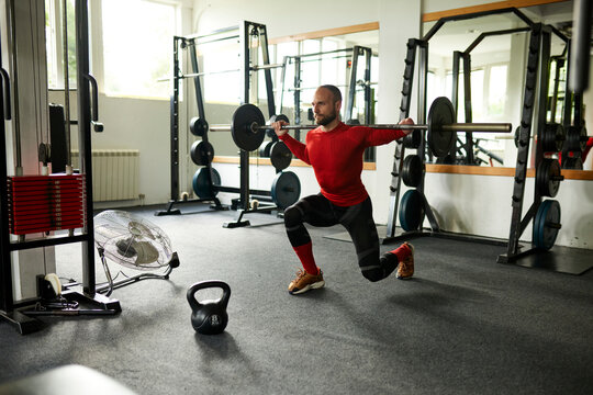 Athlete does a half squat with a barbell - Powered by Adobe