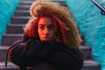 Pondering young woman with skateboard on stairs