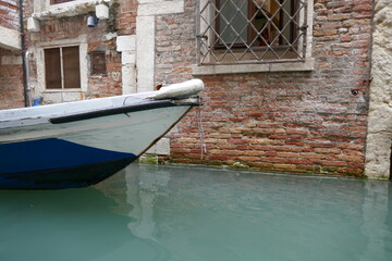 Fototapeta na wymiar Venice canal with flooded side of building and front of floating boat in water
