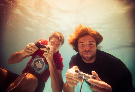 Cheerful gamers playing video games underwater