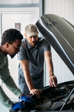 Two Mechanics Fixing Car in Garage