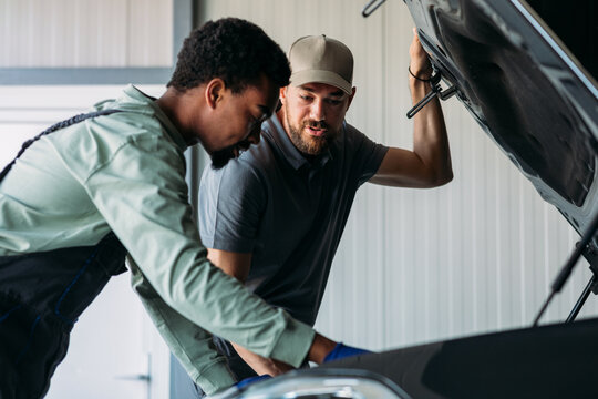 Two Mechanics Fixing Car in Garage