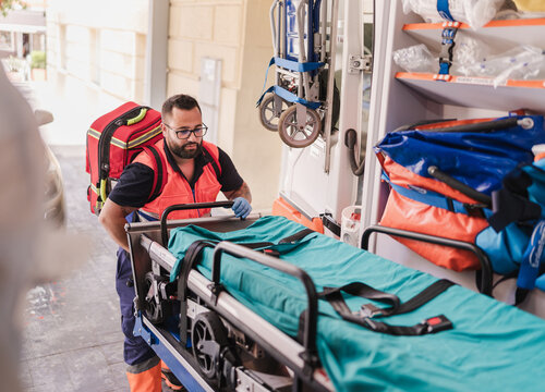 paramedic taking a stretcher out of the ambulance