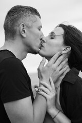 A young couple of beautiful people have fun in the field near round bales of dry hay