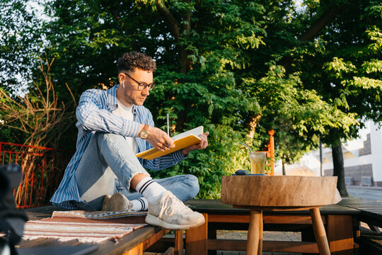 A man reads a book outdoors