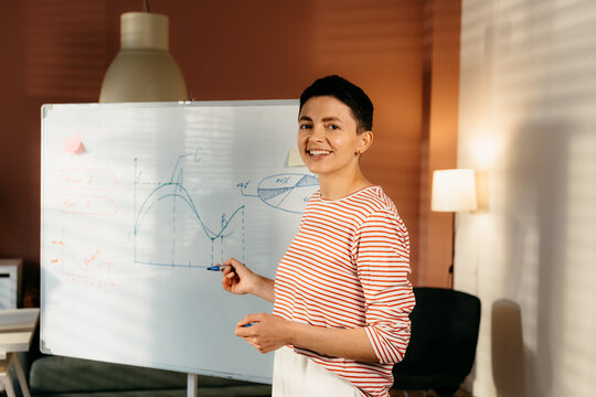 A woman smiles looking at the camera standing in the office
