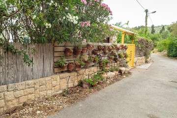 Lots  of flower pots hanging on the fence in the famous artists village Ein Hod near Haifa in northern Israel