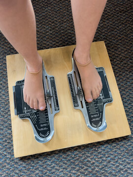 Young girl having her foot measurement to purchase shoes 