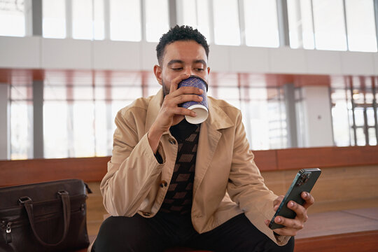 A young businessman flips  on his smartphone