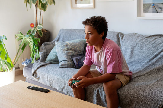 teen boy playing video games at home