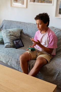 Young boy online playing with a friend