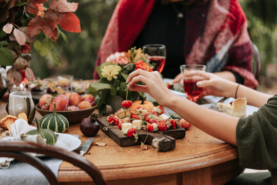 Faceless guests at table at autumn brunch.