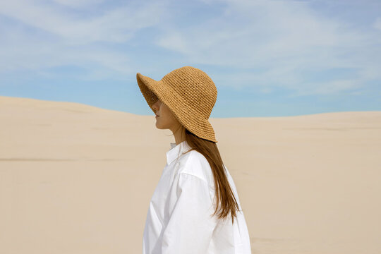 Summer portrait of a woman in sand dunes a desert background.