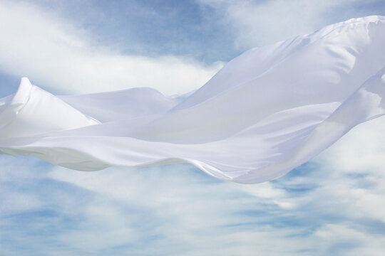 Texture of flowing white fabric against a desert background. 