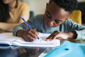Close-up of a little boy doing homework at home