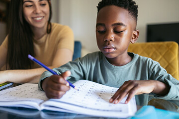 Close-up of a little boy doing homework at home