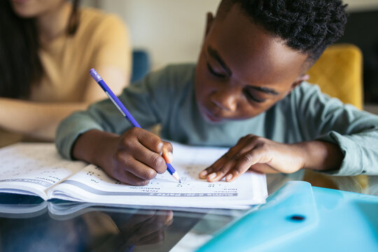 Close-up of a little boy doing homework at home