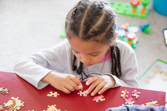Young child trying to assemble a puzzle