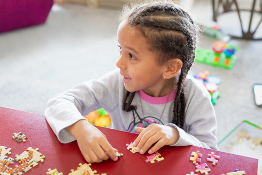 Closeup image of a child trying to assemble a puzzle