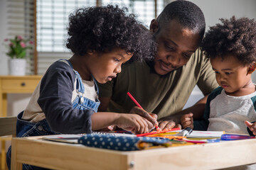 Man helping his two little son with homework at home