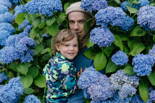 Father and child with blue beautiful flowers