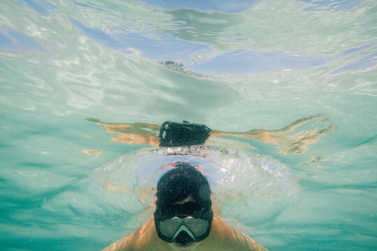 Boy diving below the surface of the ocean.