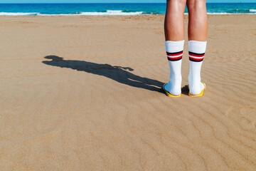 man wearing socks and flip-flops on the beach