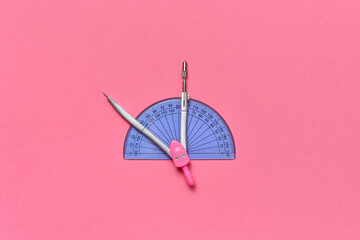 Compass and protractor against pink background.
