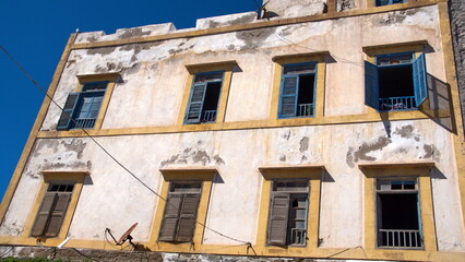 Old building with yellow trim and blue shutters above the market in Essaouira, Morocco