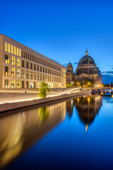 The modern backside of the City Palace, the cathedral and the river Spree in Berlin at dusk
