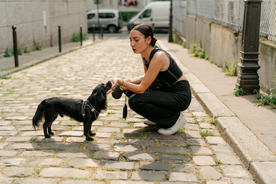 young woman with her dog in a street in Paris France 