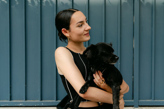 portrait of happy stylish woman in the street with her dog